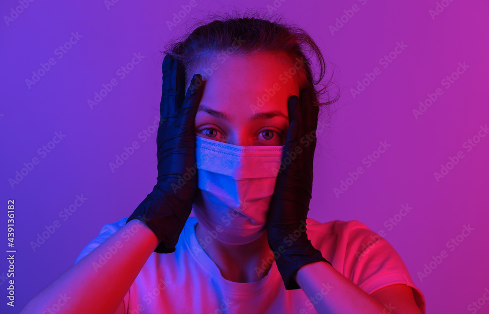 Portrait of panic woman in a medical mask. Pink blue gradient neon light. Pandemic protection covid-19 Portrait of panic woman in a medical mask. Pink blue gradient neon light. Pandemic protection covid-19