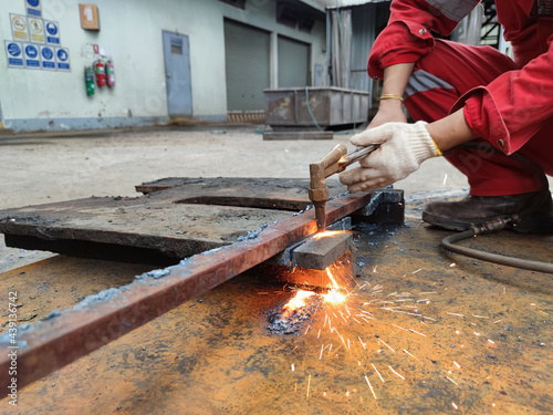 Worker cutting metal plate by Gas Cutting Torch in the workshop.