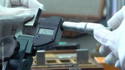 Engineer working with precise micrometer with digital display for quality control. Close up of accurate measuring instrument. Micrometer tool showing the exact diameter and thickness. photo