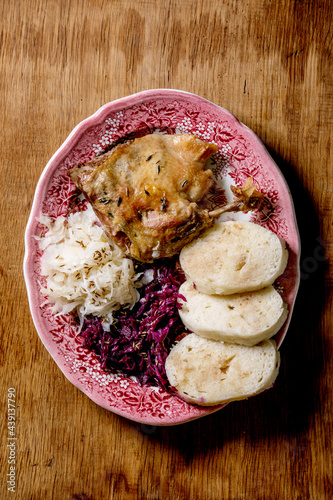 Baked duck legs with sliced boiled knedliks and sauerkraut photo