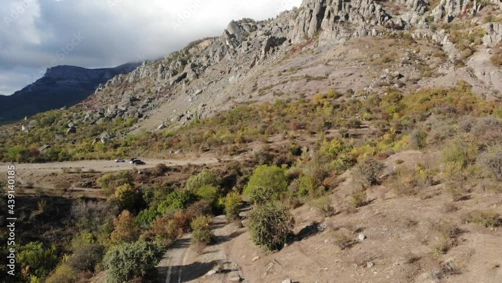 Aerial view of rocky mountain slope covered autumn plants. Aerial shooting from drone rocky mountain foot in autumn valley Aerial view of rocky mountain slope covered autumn plants. Aerial shooting from drone rocky mountain foot in autumn valley