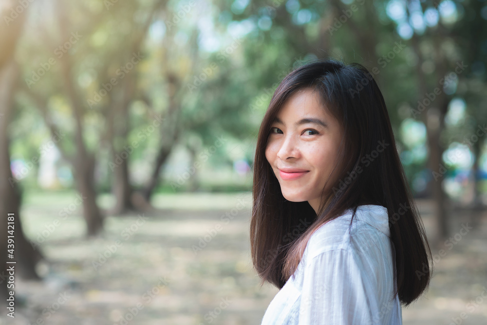 attractive adult business woman asian girl with happy and smile standing on walk way go to working between her office on morning under green forest. attractive adult business woman asian girl with happy and smile standing on walk way go to working between her office on morning under green forest.