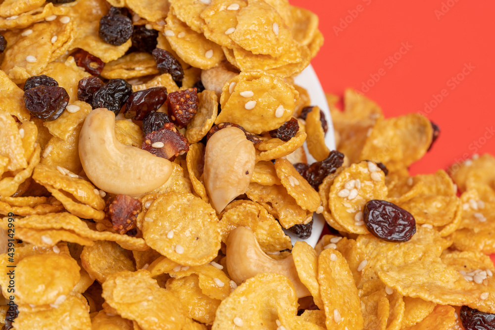 Cornflakes honey caramel homemade with grains, currant, cashew nut, dried strawberries and white sesame healthy food snack on a white plate close up and Macro copy space. Cornflakes honey caramel homemade with grains, currant, cashew nut, dried strawberries and white sesame healthy food snack on a white plate close up and Macro copy space.