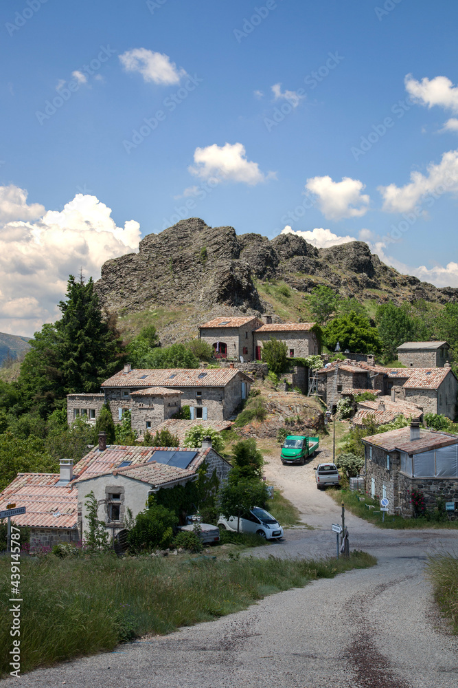 Obraz premium Le petit village d'Ajoux en Ardèche au pied de son piton volcanique