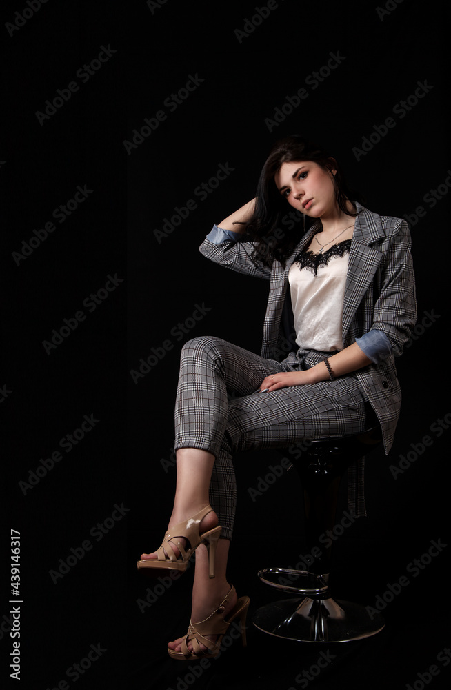 young beautiful girl in a business suit posing sitting on chair young beautiful girl in a business suit posing sitting on chair