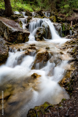 Mountain stream cascades over rocks forming a waterfall