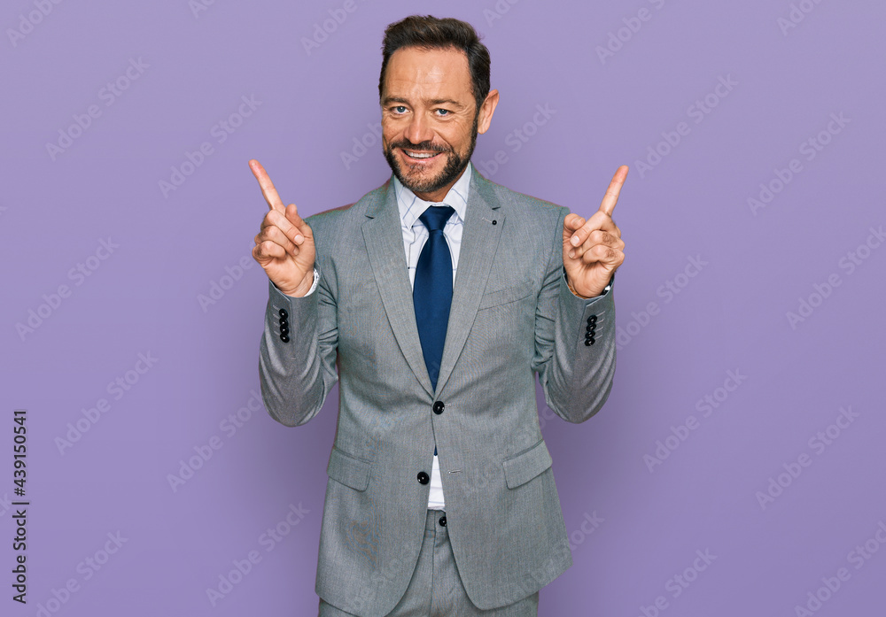 Middle age man wearing business clothes smiling confident pointing with fingers to different directions. copy space for advertisement Middle age man wearing business clothes smiling confident pointing with fingers to different directions. copy space for advertisement