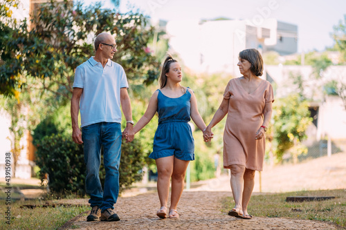 Latina family happy outdoors with daughter with down syndrome