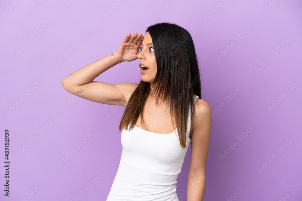 Young caucasian woman isolated on purple background with surprise expression while looking side Young caucasian woman isolated on purple background with surprise expression while looking side