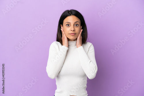 Young caucasian woman isolated on purple background frustrated and covering ears