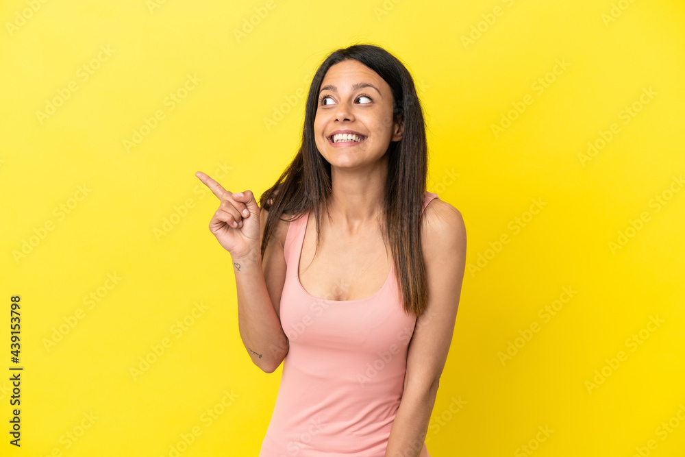 Young caucasian woman isolated on yellow background intending to realizes the solution while lifting a finger up Young caucasian woman isolated on yellow background intending to realizes the solution while lifting a finger up