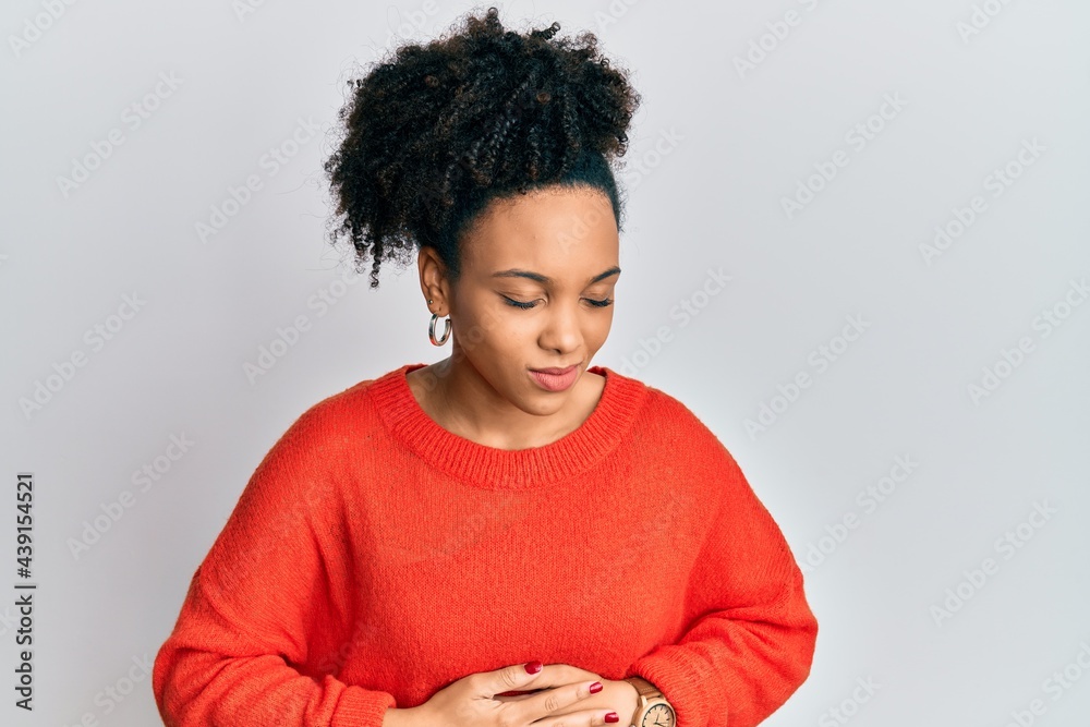 Young african american girl wearing casual clothes with hand on stomach because indigestion, painful illness feeling unwell. ache concept. Young african american girl wearing casual clothes with hand on stomach because indigestion, painful illness feeling unwell. ache concept.