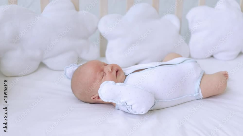 yawning newborn baby boy lying on a cotton bed at home before going to bed, the concept of birth, infancy and healthy sleep yawning newborn baby boy lying on a cotton bed at home before going to bed, the concept of birth, infancy and healthy sleep