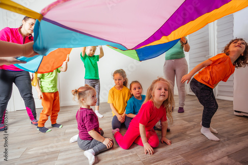 Organised team building games for kids using rainbow canopy