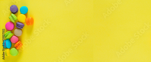 Sweet colorful macaroons on yellow background,Sweet and colorful french macaroons or macaroon on yellow background, Dessert eating with tea or coffee.