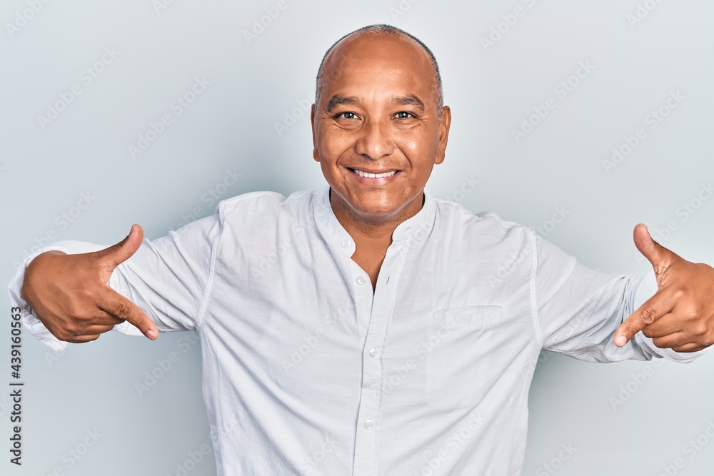 Middle age latin man wearing casual clothes looking confident with smile on face, pointing oneself with fingers proud and happy.