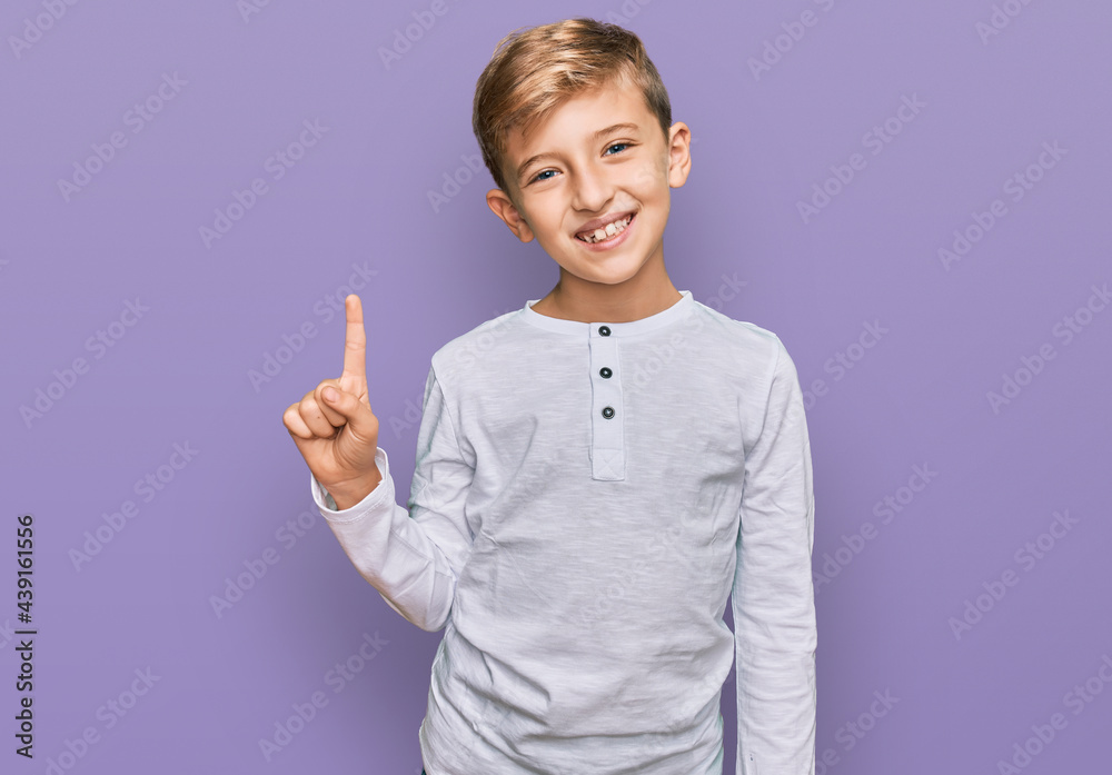Little caucasian boy kid wearing casual clothes showing and pointing up with finger number one while smiling confident and happy. Little caucasian boy kid wearing casual clothes showing and pointing up with finger number one while smiling confident and happy.