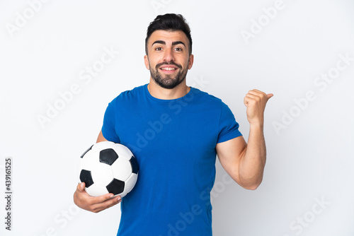 Handsome young football player man over isolated wall pointing to the side to present a product