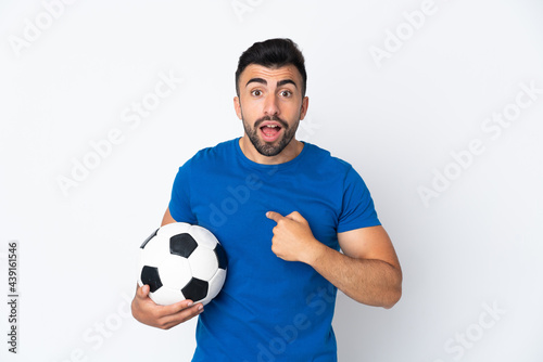 Handsome young football player man over isolated wall with surprise facial expression