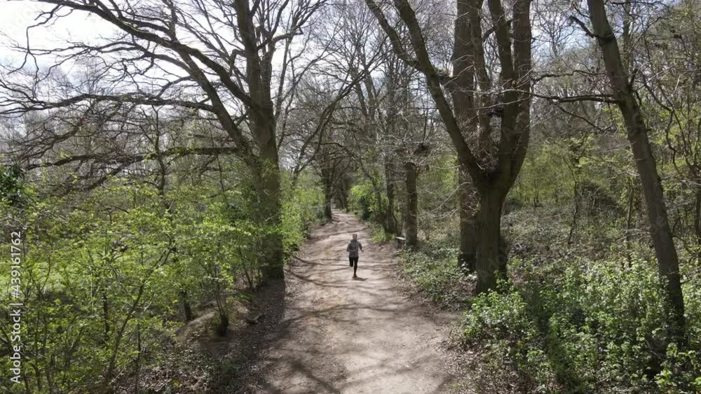 Aerial Running Shot Of Female Model Exercising in Woodland. 4k Drone Shot From Above. Health Fitness And Cardio Training.