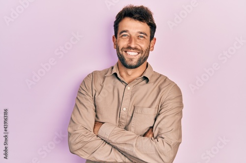 Handsome man with beard wearing casual shirt happy face smiling with crossed arms looking at the camera. positive person. © Krakenimages.com
