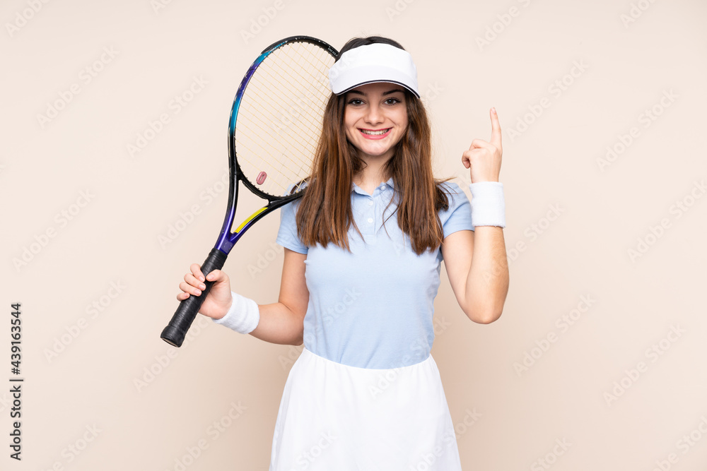 Young caucasian woman isolated on beige background playing tennis and pointing up Young caucasian woman isolated on beige background playing tennis and pointing up