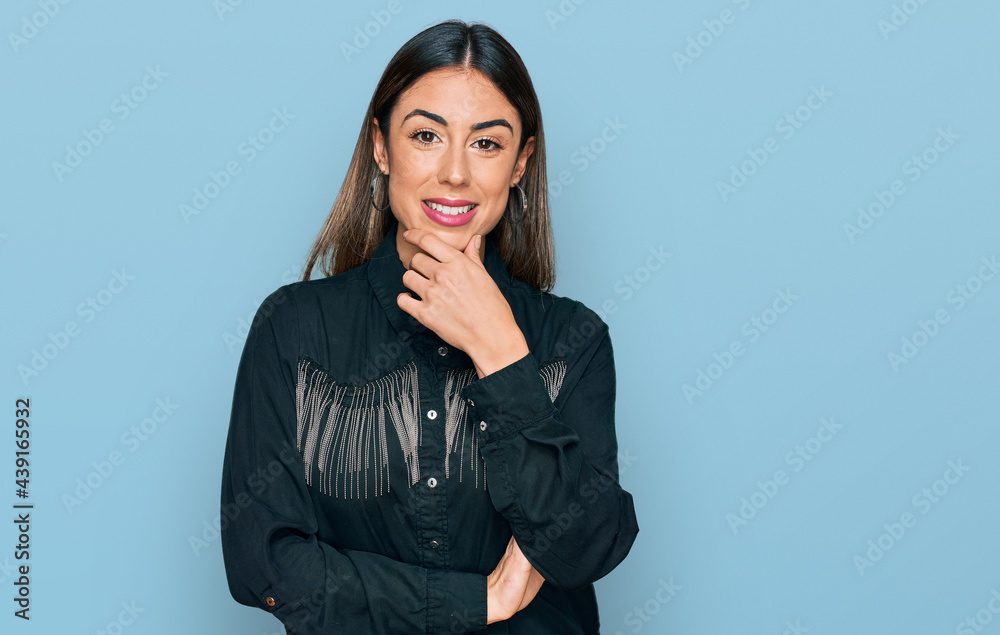 Young hispanic woman wearing casual clothes looking confident at the camera smiling with crossed arms and hand raised on chin. thinking positive. Young hispanic woman wearing casual clothes looking confident at the camera smiling with crossed arms and hand raised on chin. thinking positive.