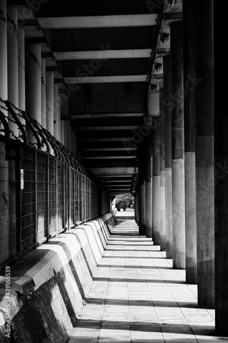 高架下の歩道に規則正しく並んだ柱と影