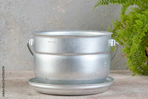 Tourist aluminium pot on concrete background.