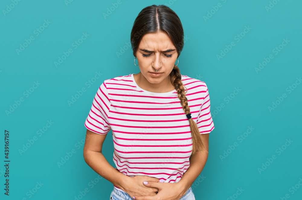 Obraz premium Young hispanic woman wearing casual clothes with hand on stomach because indigestion, painful illness feeling unwell. ache concept.