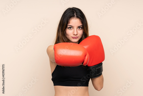 Young sport woman with boxing gloves over isolated background © luismolinero