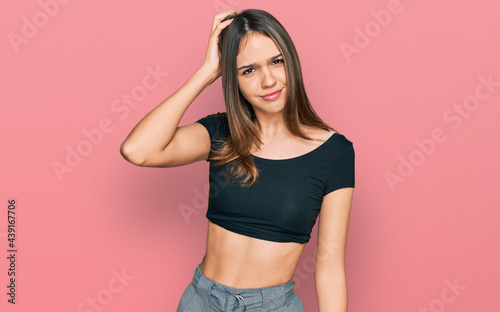 Young brunette woman wearing casual clothes confuse and wonder about question. uncertain with doubt, thinking with hand on head. pensive concept. © Krakenimages.com