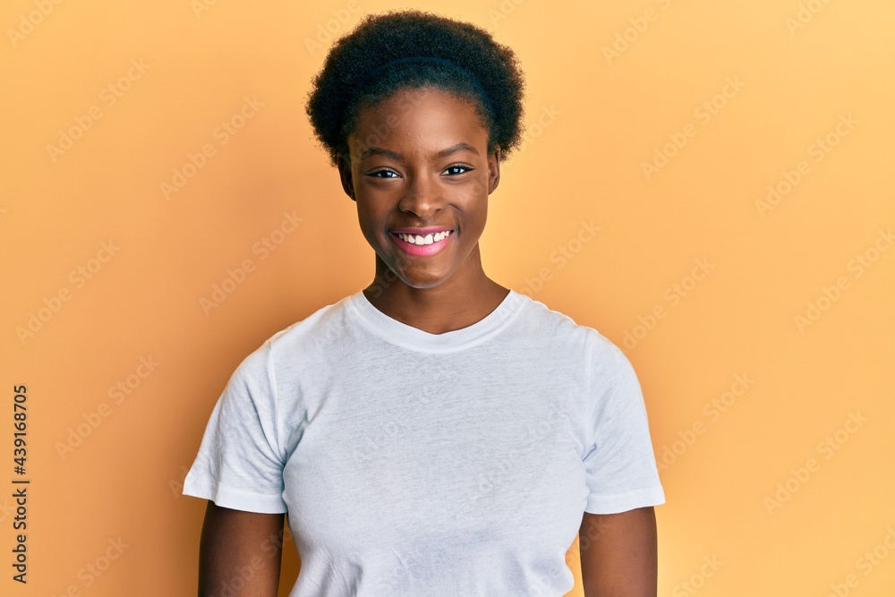 Young african american girl wearing casual white t shirt with a happy and cool smile on face. lucky person. Young african american girl wearing casual white t shirt with a happy and cool smile on face. lucky person.