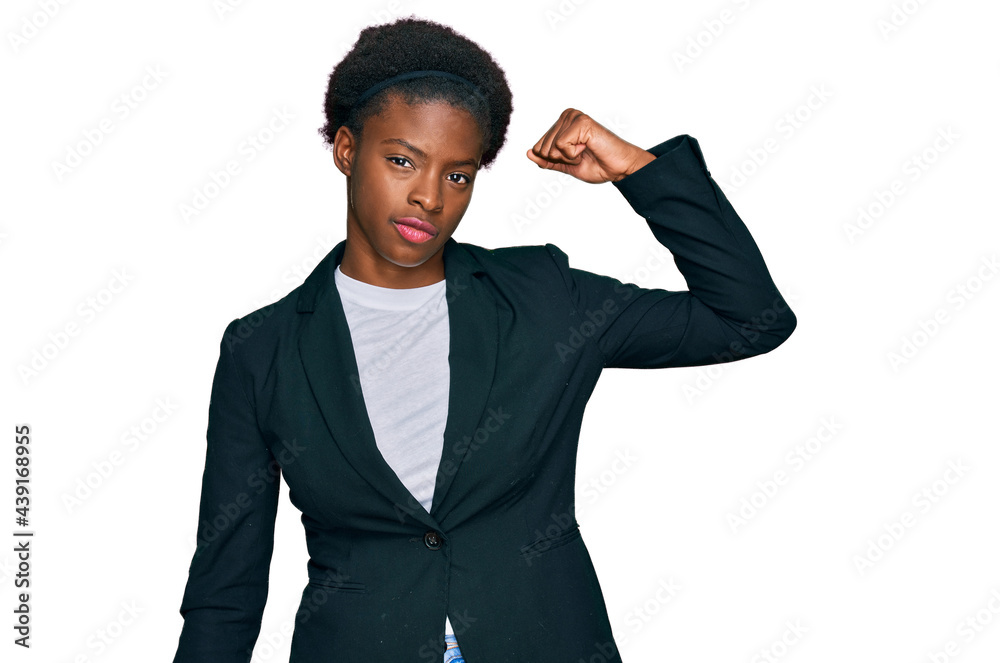 Young african american girl wearing business clothes strong person showing arm muscle, confident and proud of power Young african american girl wearing business clothes strong person showing arm muscle, confident and proud of power