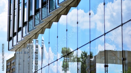 Glass and aluminum facade of a modern office building. View of futuristic architecture. Office building with cloud reflection on windows