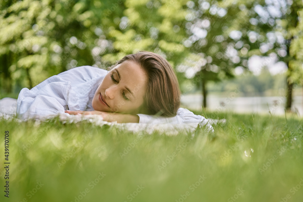 Young woman sleeping in park during sunny summer day Young woman sleeping in park during sunny summer day
