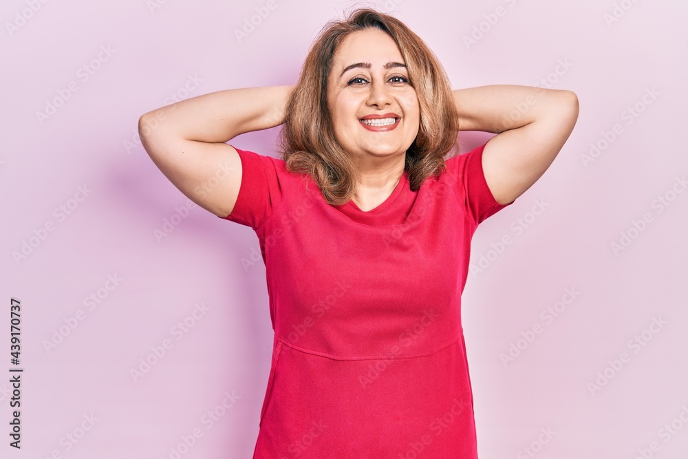 Middle age caucasian woman wearing casual clothes relaxing and stretching, arms and hands behind head and neck smiling happy Middle age caucasian woman wearing casual clothes relaxing and stretching, arms and hands behind head and neck smiling happy