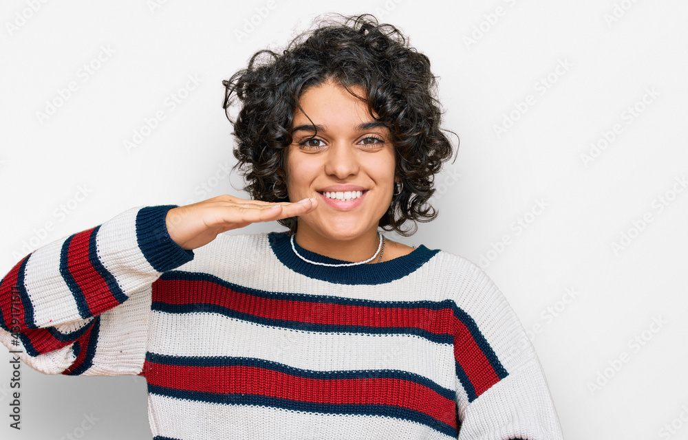 Young hispanic woman with curly hair wearing casual clothes gesturing with hands showing big and large size sign, measure symbol. smiling looking at the camera. measuring concept. Young hispanic woman with curly hair wearing casual clothes gesturing with hands showing big and large size sign, measure symbol. smiling looking at the camera. measuring concept.