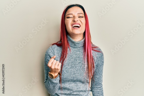 Young caucasian woman wearing casual clothes angry and mad raising fist frustrated and furious while shouting with anger. rage and aggressive concept.