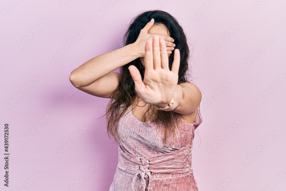 Young hispanic woman wearing casual clothes covering eyes with hands and doing stop gesture with sad and fear expression. embarrassed and negative concept. Young hispanic woman wearing casual clothes covering eyes with hands and doing stop gesture with sad and fear expression. embarrassed and negative concept.