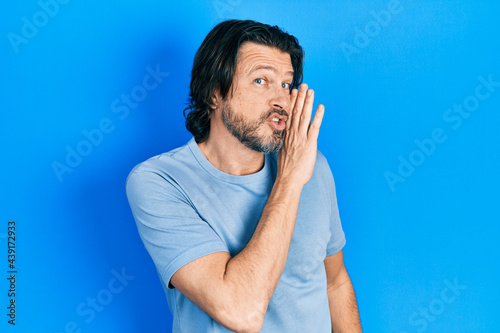Middle age caucasian man wearing casual clothes hand on mouth telling secret rumor, whispering malicious talk conversation