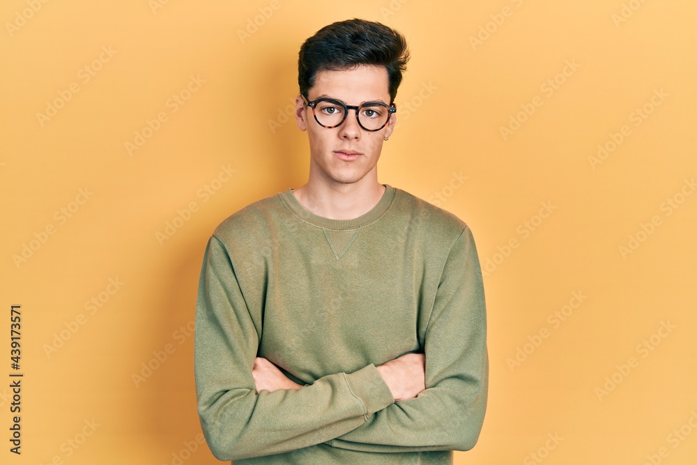 Young hispanic man with arms crossed gesture relaxed with serious expression on face. simple and natural looking at the camera. Young hispanic man with arms crossed gesture relaxed with serious expression on face. simple and natural looking at the camera.