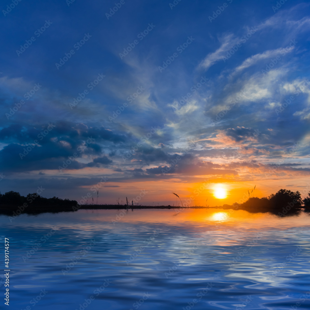 Obraz premium dramatic sunset reflected in quet lake, countryside natural sunset background