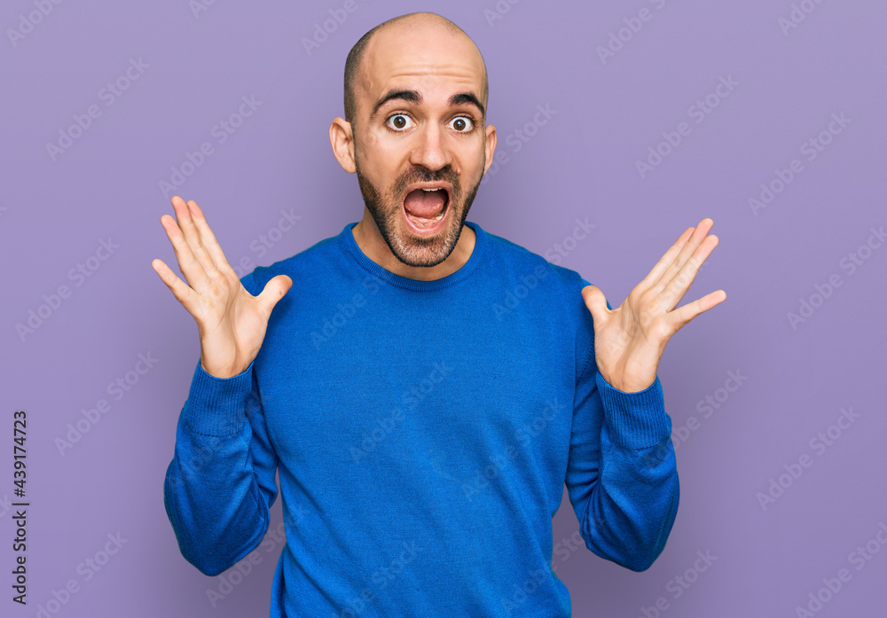 Young hispanic man wearing casual clothes celebrating crazy and amazed for success with arms raised and open eyes screaming excited. winner concept