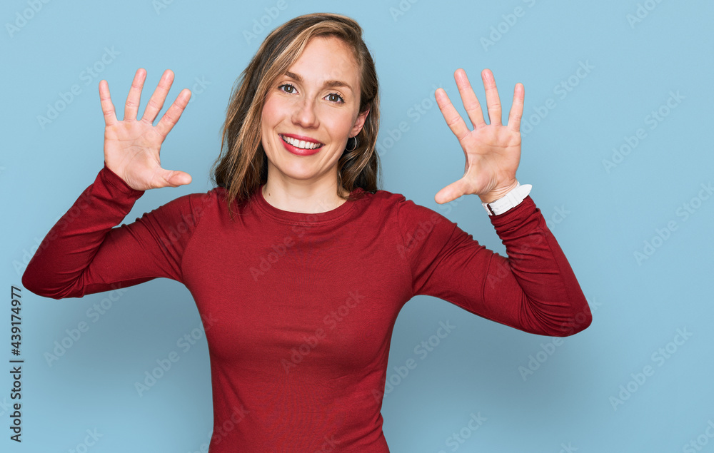 Young blonde woman wearing casual clothes showing and pointing up with fingers number ten while smiling confident and happy. Young blonde woman wearing casual clothes showing and pointing up with fingers number ten while smiling confident and happy.