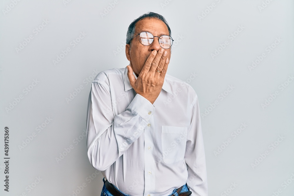 Middle age indian man wearing casual clothes and glasses bored yawning tired covering mouth with hand. restless and sleepiness. Middle age indian man wearing casual clothes and glasses bored yawning tired covering mouth with hand. restless and sleepiness.