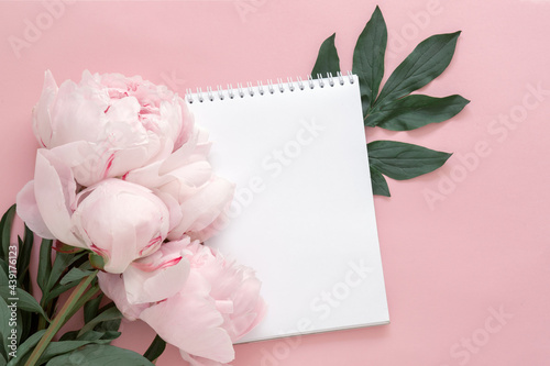 Fototapeta Naklejka Na Ścianę i Meble -  notepad and peony flower on pink background, concept of goal setting, summer plans, wish list, shopping, blank message sheet, romantic card, mock up for design