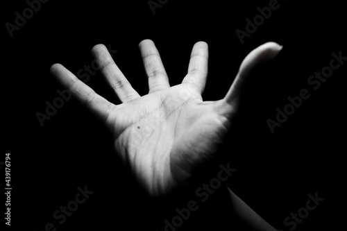 Foto palma de mano de mujer hacia el cielo recibiendo con fondo negro