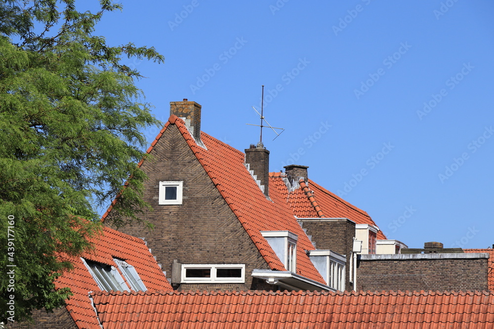 Amsterdam Brown Brick Building Detail with Red Roof Tiles Against a Blue Sky, Baarsjes District Amsterdam Brown Brick Building Detail with Red Roof Tiles Against a Blue Sky, Baarsjes District