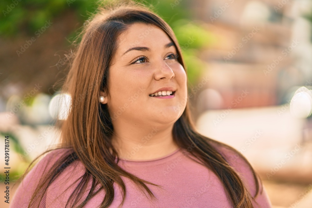Obraz premium Young hispanic plus size woman smiling happy standing at the city.